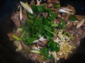 再倒入青椒块、大蒜末翻炒