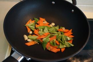 炒锅中倒适量油，入蒜片炒出香味，依次将胡萝卜片、尖椒块入锅中翻炒变色
