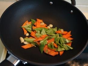 炒锅中倒适量油，入蒜片炒出香味，依次将胡萝卜片、尖椒块入锅中翻炒变色