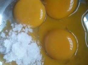 蛋黄，蛋白分别打入两个容器，蛋白的容器要求无水无油。蛋黄中加入40克细砂糖隔温水加热，边加热边用手动打蛋器搅拌。至蛋液达到38度左右时离火