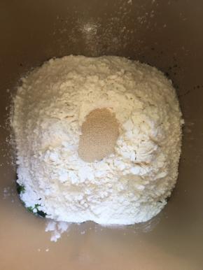 除黄油外的所有材料放入面包机桶内，先放液体，糖和盐对角放，在倒入面包粉，上面挖个坑，放入酵母