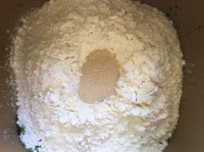 除黄油外的所有材料放入面包机桶内，先放液体，糖和盐对角放，在倒入面包粉，上面挖个坑，放入酵母