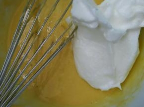 取三分之一的蛋白霜放入蛋黄糊里快速的搅拌均匀