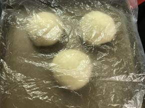 4、把发酵好的面团分割成150克一个的小面团，盖保鲜膜室温醒发30分钟。