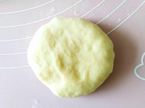 4.取一个松弛好的面团，用掌心压扁。
