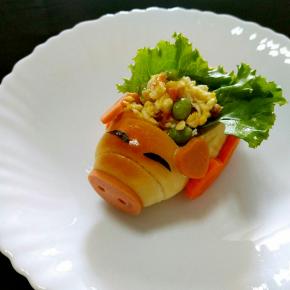 将小猪敞篷车的耳朵，眼睛，鼻子分别用少许沙拉酱粘在合适的位置，挖空的位置放入一小片生菜叶，装入拌好的鸡蛋蔬菜沙拉即可。