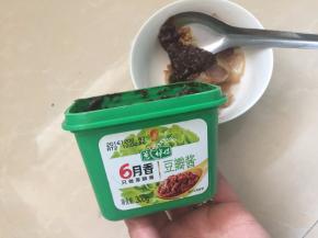 勺入两勺豆瓣酱到五花肉中