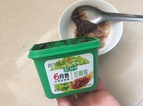 勺入两勺豆瓣酱到五花肉中