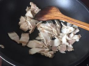 五花肉用开水煮熟后切成薄片，然后放入锅中煸出油，煸至表面金黄即可