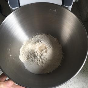 高筋面粉、倒入厨师机盆内，中间挖一小孔倒入即发活性干酵母，盐和细砂糖对角线放置，倒入牛奶