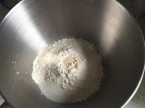 高筋面粉、倒入厨师机盆内，中间挖一小孔倒入即发活性干酵母，盐和细砂糖对角线放置，倒入牛奶