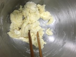 一边搅拌一边倒入热水，搅成絮状，再揉成光滑面团，揉到能拉出薄膜