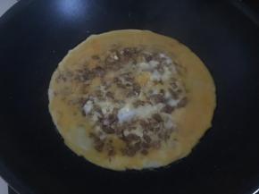 然后倒入打散的鸡蛋煎至两面金黄