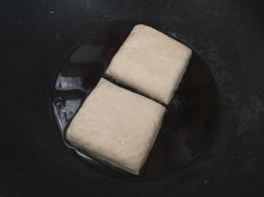 锅里倒入适量油，放入豆干煎至两面金黄