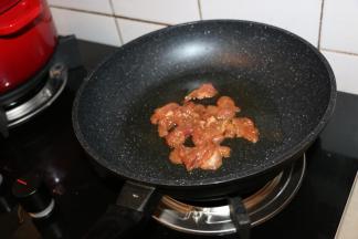 锅内倒入适量食用油，先煸炒肉片，肉片变色后放入葱姜爆香。