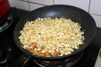 放入豆芽翻炒，加入酱油调色，撒少许盐。