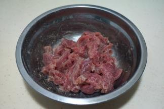 牛肉切薄片，加少许料酒、一点盐、一小勺淀粉抓匀，腌一会儿
