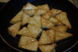 平底煎锅中倒适量油，油5成热左右时，将豆腐片入锅中，小火，两面煎金黄盛出