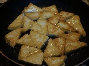 平底煎锅中倒适量油，油5成热左右时，将豆腐片入锅中，小火，两面煎金黄盛出