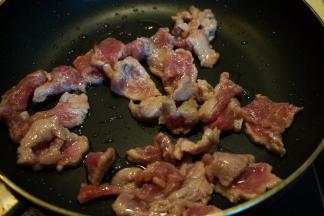 炒锅中倒少许油，将牛肉片入锅中，快速划散，变色