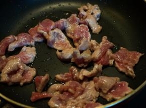 炒锅中倒少许油，将牛肉片入锅中，快速划散，变色