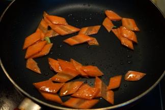 锅中留底油，将胡萝卜片略炒一下，盛出