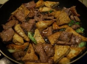 将豆腐片入锅中翻拌均匀，撒少许盐、倒少许酱油、少许热水，咕嘟一分钟，让汤能吸进豆腐中