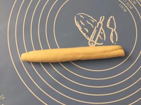 在宽的一面卷起，然后在案板上滚搓实