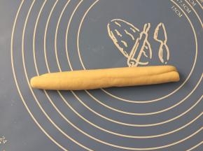 在宽的一面卷起，然后在案板上滚搓实