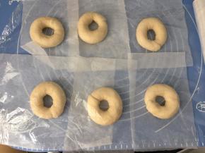 然后将面圈放在油纸上用保鲜膜封住，静置25分钟（醒发至1.5倍大）