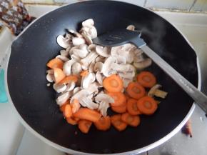 锅里加入菜油加入蘑菇及胡萝卜炒