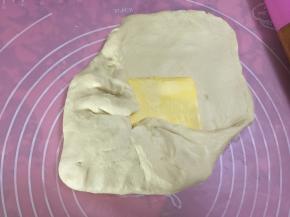 将酥油分成均等的两块，分别包入擀好的面皮中