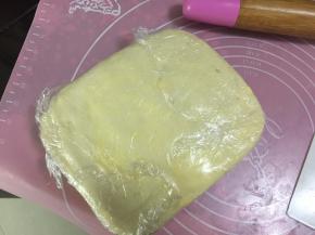 然后取一张足够大的保鲜膜封好，用擀面杖轻轻擀平擀开，再放入冰箱冷藏20分钟