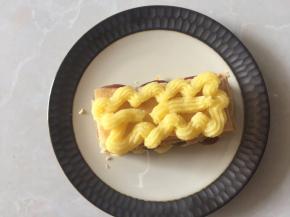 再放入一层酥皮，挤入卡仕达酱