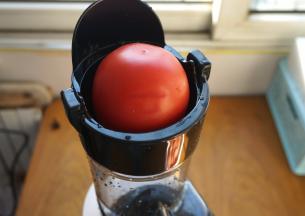 原汁机清洗干净后，通电，将西红柿直接放在进料口即可