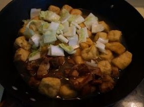 红烧肉取适量，入锅中，将白菜帮子也入锅中，倒入适量的热水和酱油，盖盖，中火煮开