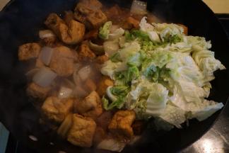 白菜帮子熟了，豆泡吸汁入味了，将白菜叶入锅中，再撒适量盐，菜叶变软就可关火出锅