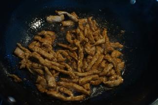 热锅凉油，将肉丝入锅，用铲子尖或者筷子迅速划散，再倒入适量的酱油调色入味，盛出备用