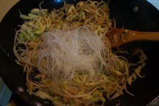 将粉丝入锅中，倒少许热水翻炒入味