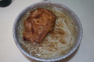 煮熟的面条捞入碗中，想喝浓稠的就用原汤，想喝清爽点的就倒热水，将猪排夹入碗中，再倒点酱油