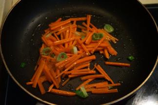 炒锅中倒入适量的橄榄油，将葱花煸炒出香味，再倒入胡萝卜丝煸炒变色