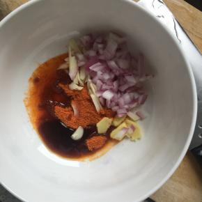 洋葱切丁，大蒜切细，姜切片，放入大碗中，倒入新奥尔良腌料，倒入适量玉米油、蚝油