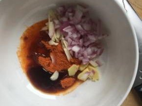 洋葱切丁，大蒜切细，姜切片，放入大碗中，倒入新奥尔良腌料，倒入适量玉米油、蚝油