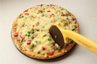 烤好的披萨用披萨轮刀切块食用，一定不能直接用刀子切，不然盘子就切坏了。