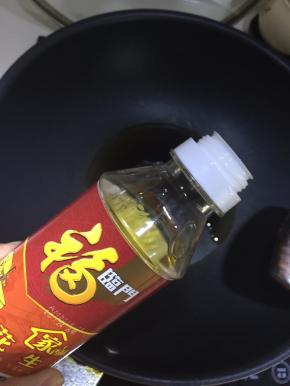 将花生油倒入锅里热油锅