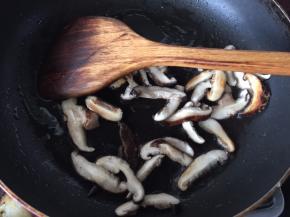 锅里热油放入切片的香菇爆香