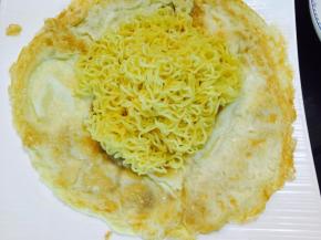将面条捞出放在鸡蛋饼上