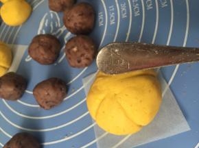 包好的南瓜饼用汤匙柄压出南瓜纹路