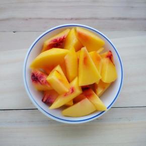 在预热的时候，将黄桃洗净去皮，切成块。