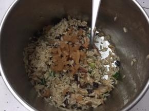 将切片的香菇、自制广式腊肠、自制广式腊肉、干贝、菜脯粒、葱花、蚝油、生抽、芝麻香油、盐、白砂糖放入米中搅拌均匀